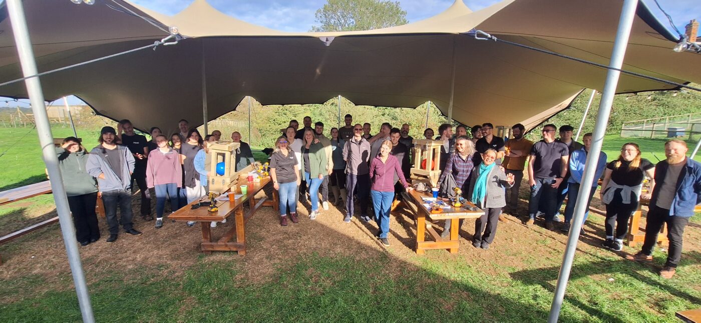 Corporate delegates engaging in outdoor team‑building tasks at Jimmy’s Farm’s countryside setting.
