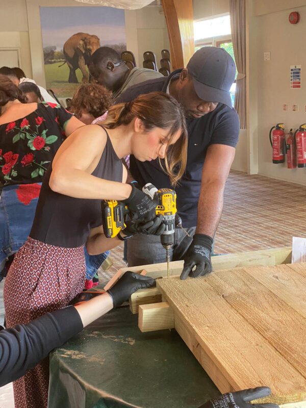 “Corporate group engaging in a CSR activity overlooking the wildlife habitats at Woburn Safari Park.” “Employees collaborating during a team building session at Woburn Safari Park’s Safari Lodge event space.”