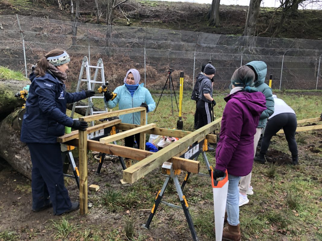 Corporate team taking part in a hands‑on team‑building challenge at Five Sisters Zoo to support conservation initiatives.